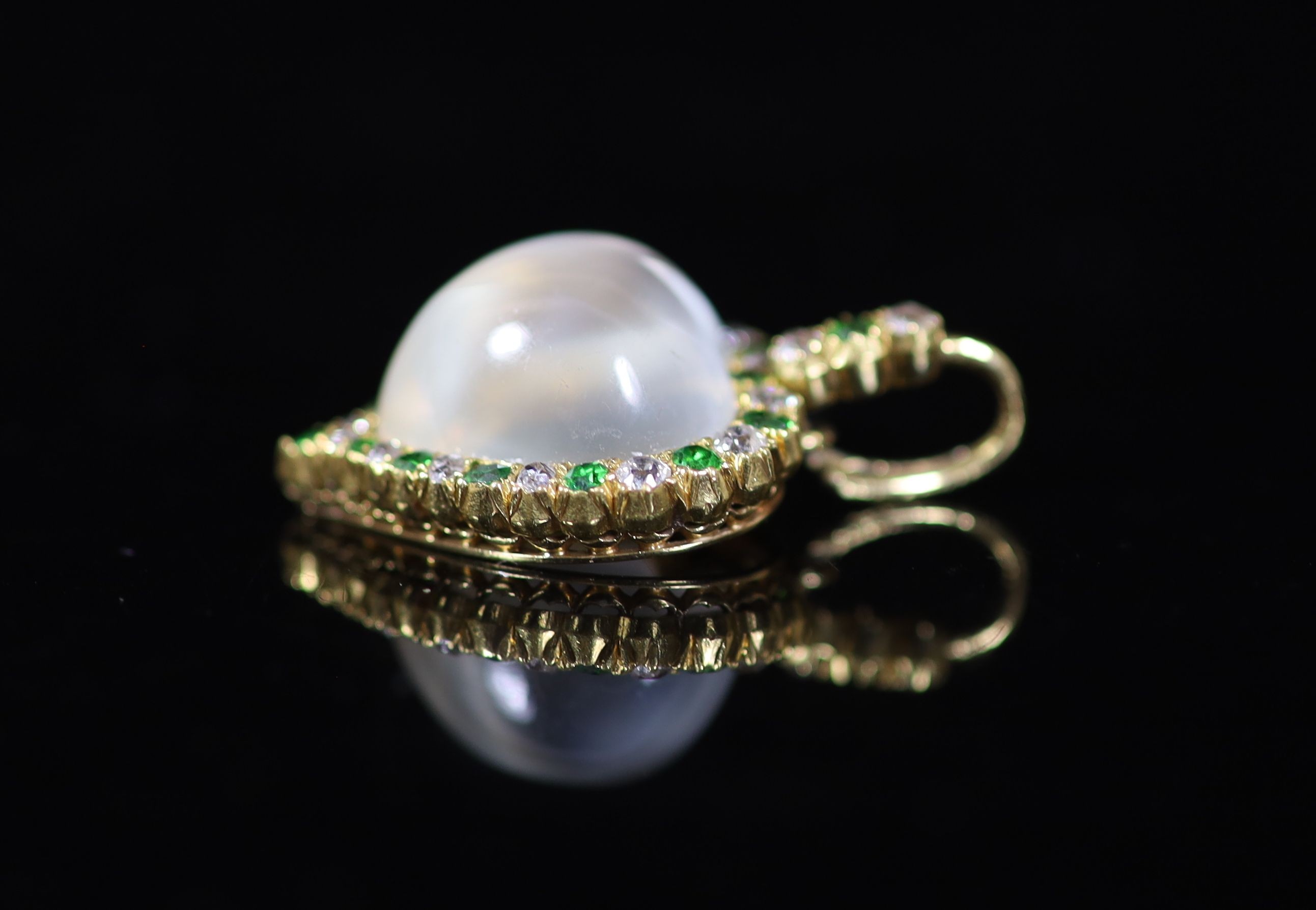 An early 20th century gold, moonstone, diamond and green garnet set heart shaped pendant